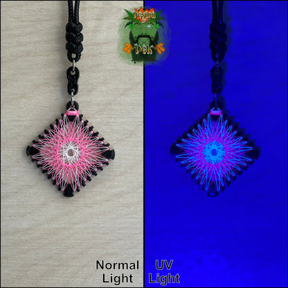 A square pendant necklace with a black cord, featuring neon string art in white and pink. The image is split into two halves: the left shows the pendant under normal light on a beige background, and the right shows it glowing under UV light on a deep blue background.